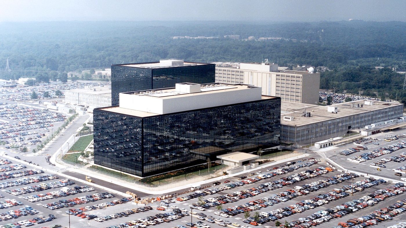 Aerial view of the National Security Agency headquarters at Fort Meade, Maryland: dark glass office blocks surrounded by large car parks.
