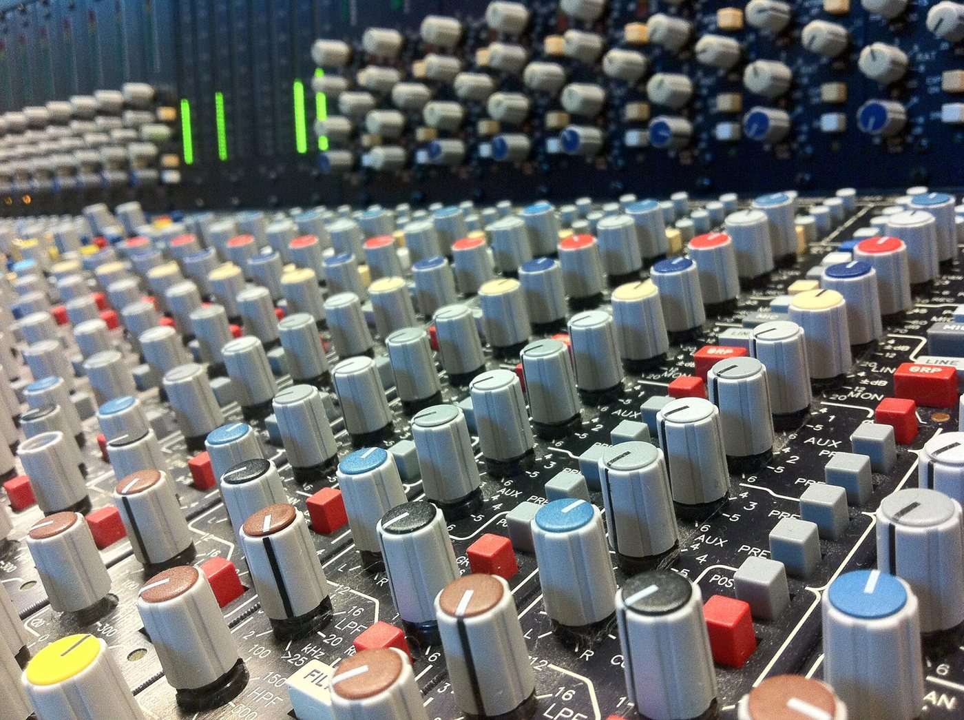 Des rangées de boutons rotatifs à capuchons colorés sur une console de mixage analogique, dans un studio de production musicale de Cologne, en Allemagne.